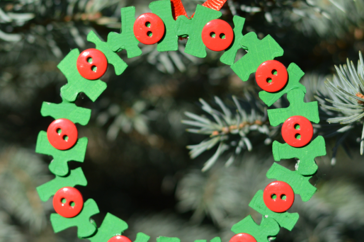 Transform old puzzle pieces and buttons into a lovely kid make wreath ornament for the Christmas tree.
