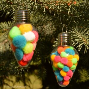This Pom Pom Filled Christmas Ornament is a super simple and inexpensive ornament for kids to make that works on fine motor skills and hand-eye coordination.